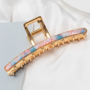 Detail of large gold metal shark hair claw clip with colorful marble resin inlay