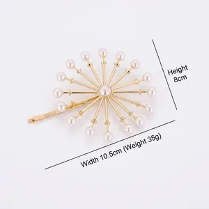 Pince à cheveux fleurie dorée avec perles et strass sur fond blanc épuré