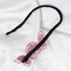 Outil chignon noir élégant avec trois papillons roses brodés sur fond de satin soyeux