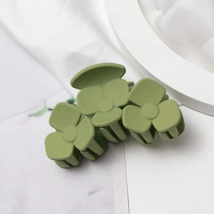 Pince à cheveux mate verte à trois fleurs avec finition givrée sur fond blanc élégant