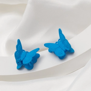 Mini mollette per capelli a farfalla blu opaco su sfondo di seta bianca chic