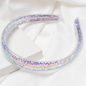 Détail d'un serre-tête transparent avec paillettes d'étoiles mauves et dents antidérapantes