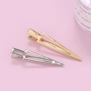 Barrettes à cheveux triangulaires évidées en métal doré et argenté sur fond rose doux