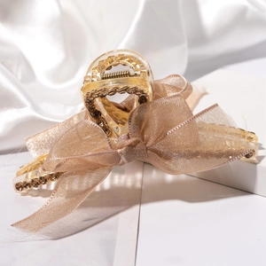 Pince à cheveux étincelante avec strass et grand nœud en soie champagne élégante