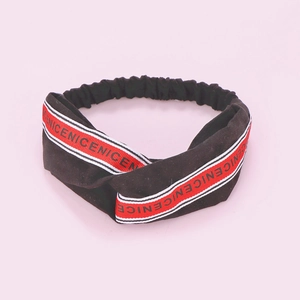 Detail of black knotted headband featuring red and white NICE lettered ribbon texture