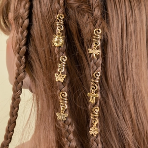 Close-up of golden spiral hair clips with charms on braided hair for styling