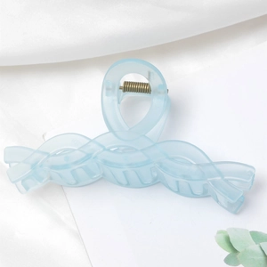 Detail of light blue translucent hair claw clip with a matte finish and twisted design