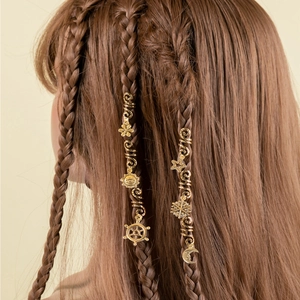 Close-up of golden spiral hair charms featuring sun, moon, and star pendants for braids
