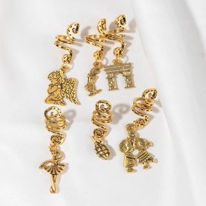 Detailed view of six vintage gold spiral hair rings with various unique metal pendants