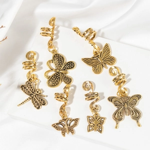 Detailed view of vintage gold metal butterfly and dragonfly spiral hair clips on a stone stand