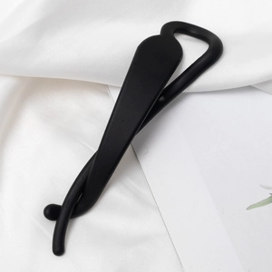 Pince à cheveux banane noire mate minimaliste avec design croisé sur soie blanche