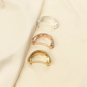 Vue détaillée de trois pinces à queue de cheval métalliques avec strass en or, argent et rose