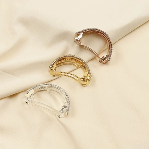 Vue détaillée de pinces à cheveux incurvées avec strass en or rose, doré et argent brillant