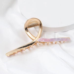 Détail de la pince à cheveux en métal doré avec résine d'acétate marbrée rose