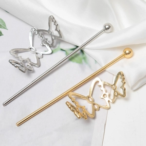 Elegant gold and silver metal hair sticks with hollow bow design on white satin fabric