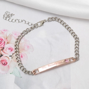 Detail of rose gold plate bracelet with His Beauty text and pink crystal inlay