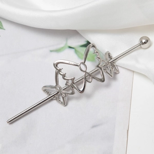 Detailed close-up of a silver hair pin featuring three hollowed butterfly shapes and polished finish