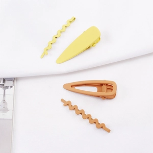 Vue détaillée d'un lot de 4 barrettes géométriques en jaune et rouge brique mat