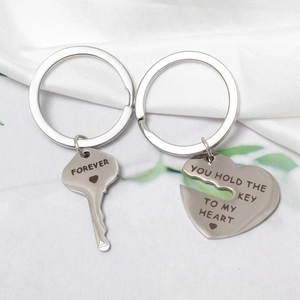 Macro shot of stainless steel couple keychains with forever key and heart pendant