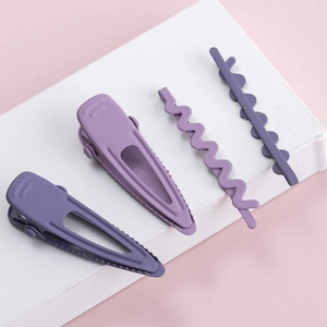 Détail d'un lot de 4 barrettes violettes mates en métal avec motifs ondulés et gouttes