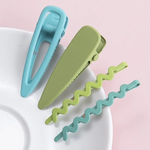 Gros plan de barrettes géométriques mates aux tons pastel posées sur un bol en céramique