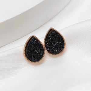 Detail of drop-shaped black druzy stud earrings with golden beaded metallic edges