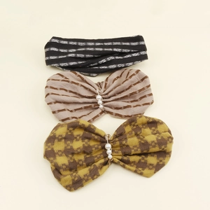 Detailed view of striped knit headbands with pearl accents and bow designs