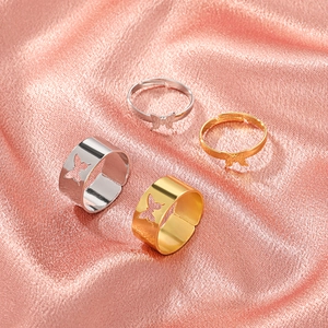 Flat lay of butterfly ring set in gold and silver finish on soft pink silk fabric