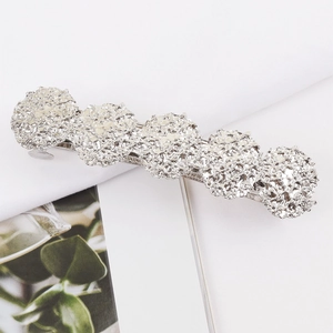 Minimalist silver hair clip with five round metallic beads on white fabric background