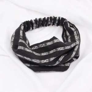 Detail of black and white striped knitted headband with cross design and elastic texture