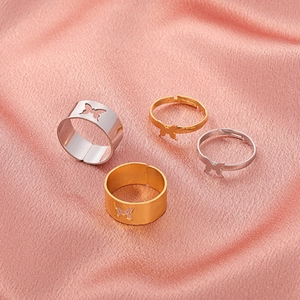 Detailed set of 4 adjustable butterfly rings in gold and silver finish on silk background