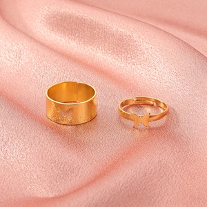 Detail of adjustable gold butterfly ring set on pink satin fabric background