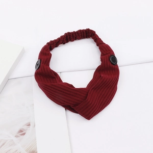 Detail of burgundy ribbed knit headband with side buttons and stylish twist design