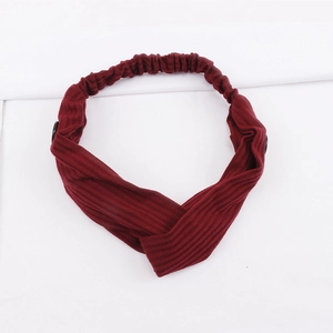 Close-up of wine red ribbed headband featuring black buttons and twisted knot detail