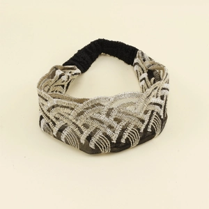 Detail view of vintage striped knit headband with gold and silver embroidery and elastic band