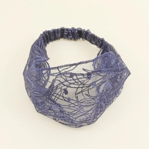 Detailed close-up of a navy blue lace mesh headband with fine embroidered textures