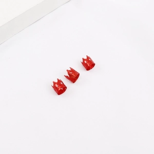 Detalle de anillos rojos para rastas en forma de corona con textura grabada