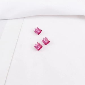 Vista detallada de tres cuentas de aluminio rosa en forma de corona para rastas