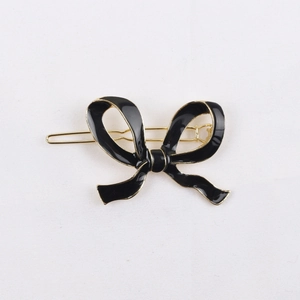 Vue détaillée d'une barrette à cheveux nœud en émail noir avec placage en alliage d'or
