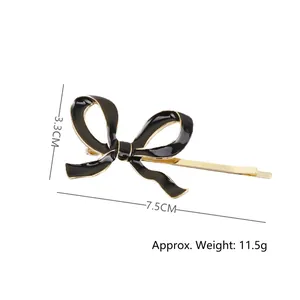 Pince à cheveux dorée avec nœud en émail noir design élégant longueur 7,5 cm