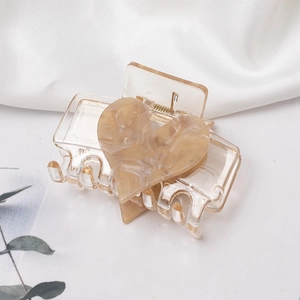 Eleganter bernsteinfarbener Herz-Haarklammer mit Marmormuster und goldener Metallfeder