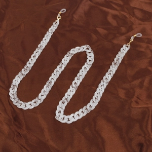 Detailed view of translucent white acrylic link chain with gold lobster clasps and silicone loops