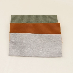 Detailed macro view of olive, orange and gray knitted headbands with ribbed texture
