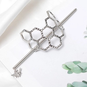 Detailed macro view of silver honeycomb alloy hair pin with a delicate bee pendant