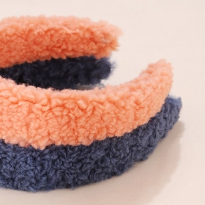 Detail of soft lamb wool headband showing fluffy texture in orange and blue colors