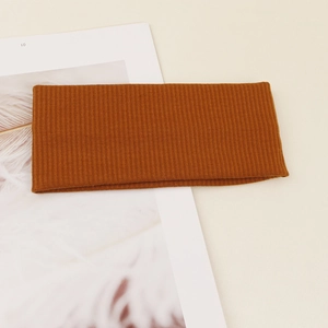 Detailed macro view of the caramel ribbed knit texture on this elastic yoga headband