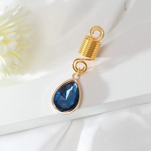 Detailansicht goldene Haarspirale mit birnenförmigem blauem Kristallanhänger für Zöpfe