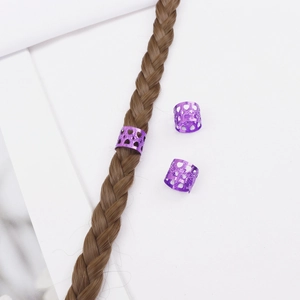 Détail de bagues de tresse en métal violet en forme de cœur sur une mèche de cheveux tressés