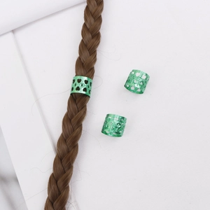 Vue détaillée d'anneaux de cheveux en métal vert ajustable avec motifs de cœur évidés