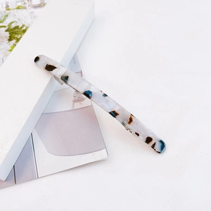 Detail showing marble texture acetate hair clip on aesthetic minimalist magazine prop